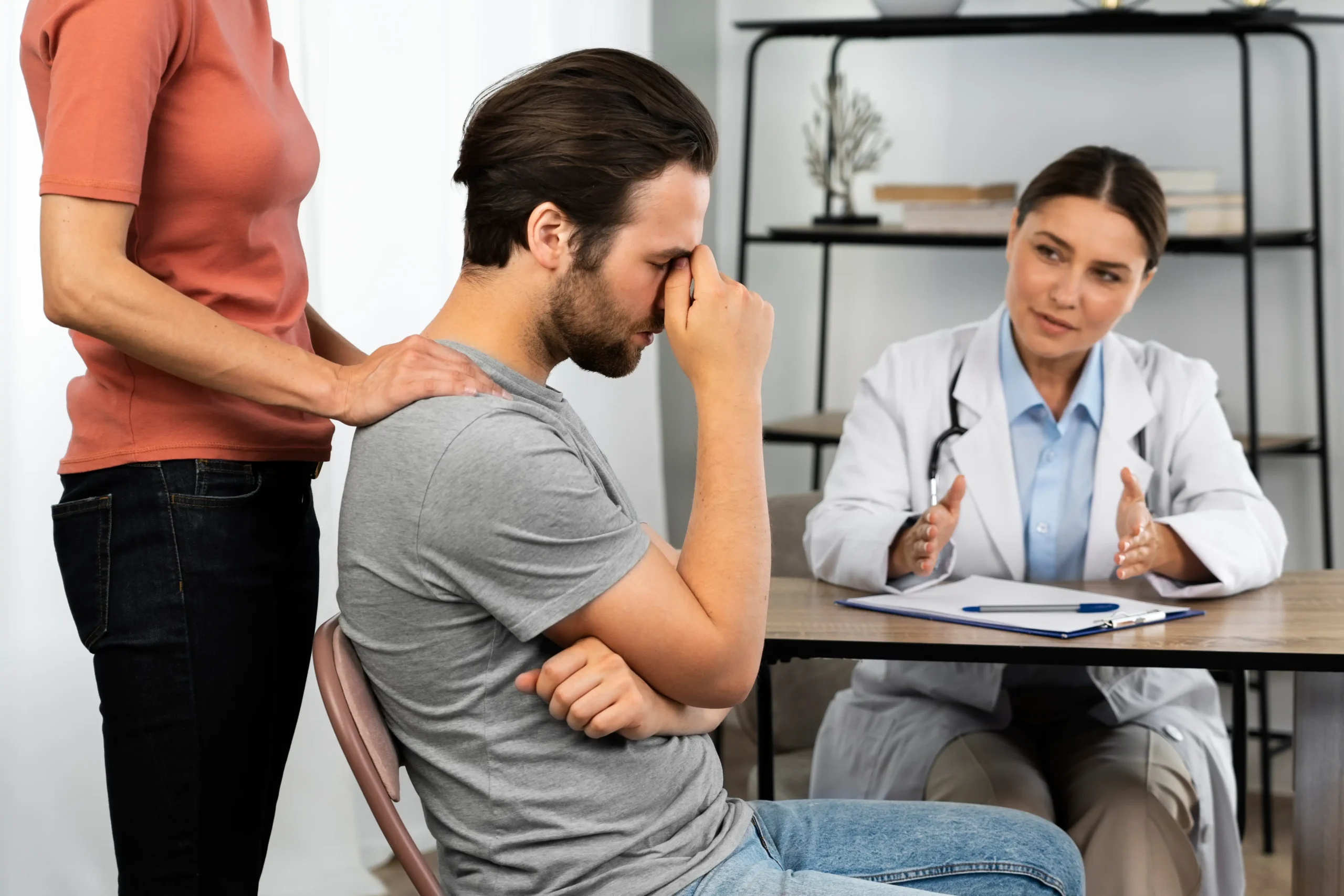 Plano de saúde negou cirurgia de paciente, que está aflito acompanhado por familiar e conversando com médica
